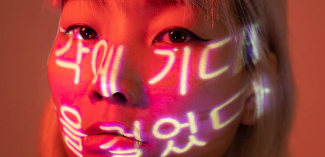 Coreana com escritas em coreano projetadas no rosto